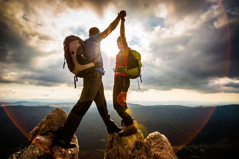 Woman And Man Hiking In Mountains