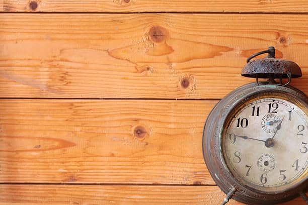 Old Vintage Mechanical Alarm Watch On The Background Of Wooden Boards