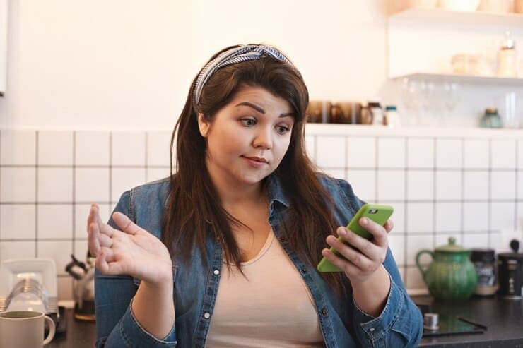 Shocked Emotional Young Overweight Woman Wearing Xxl Jeans Jacket Reading Texting Kitchen Home Having Puzzled Look While Surfing Internet Using Mobile Phone Kitchen Breakfast 344912 36