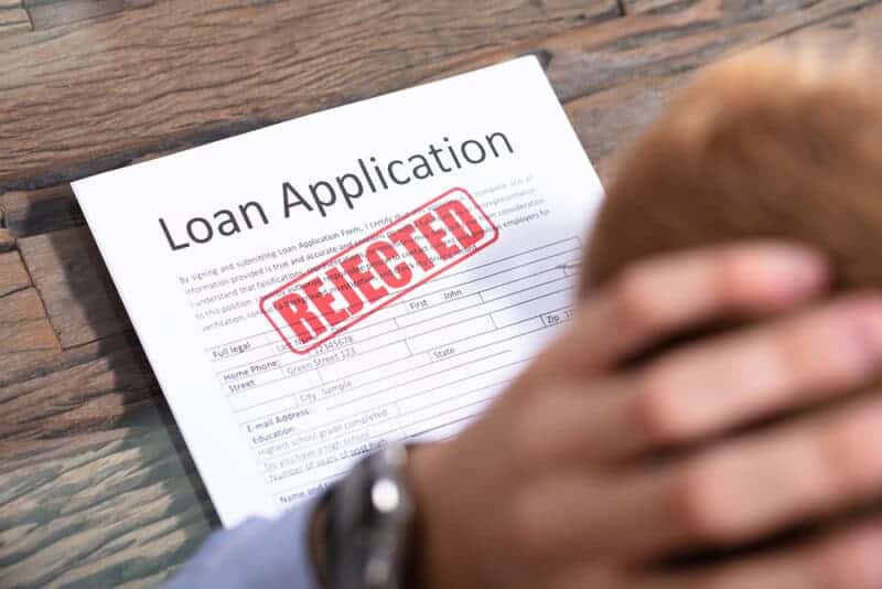 Stressed,person,looking,at,rejected,loan,application