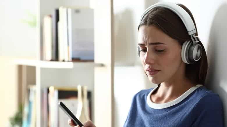 Sad,teen,complaining,listening,to,music,looking,down,and,crying