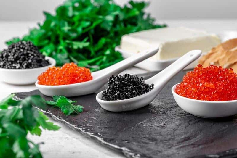 Food background with black and red caviar butter and parsley