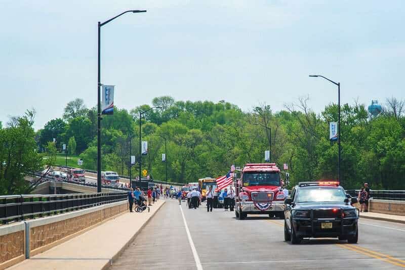 a group of people walking across a bridge